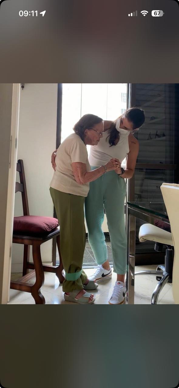 Danielle auxiliando paciente em treino de equilíbrio e transferência