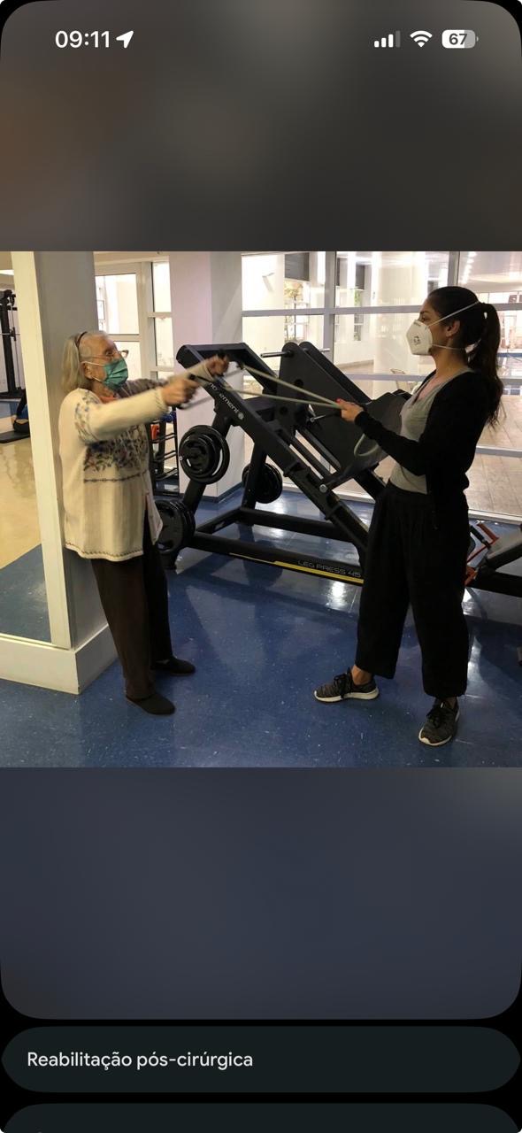 Paciente idosa em reabilitação com exercício de resistência guiado pela fisioterapeuta